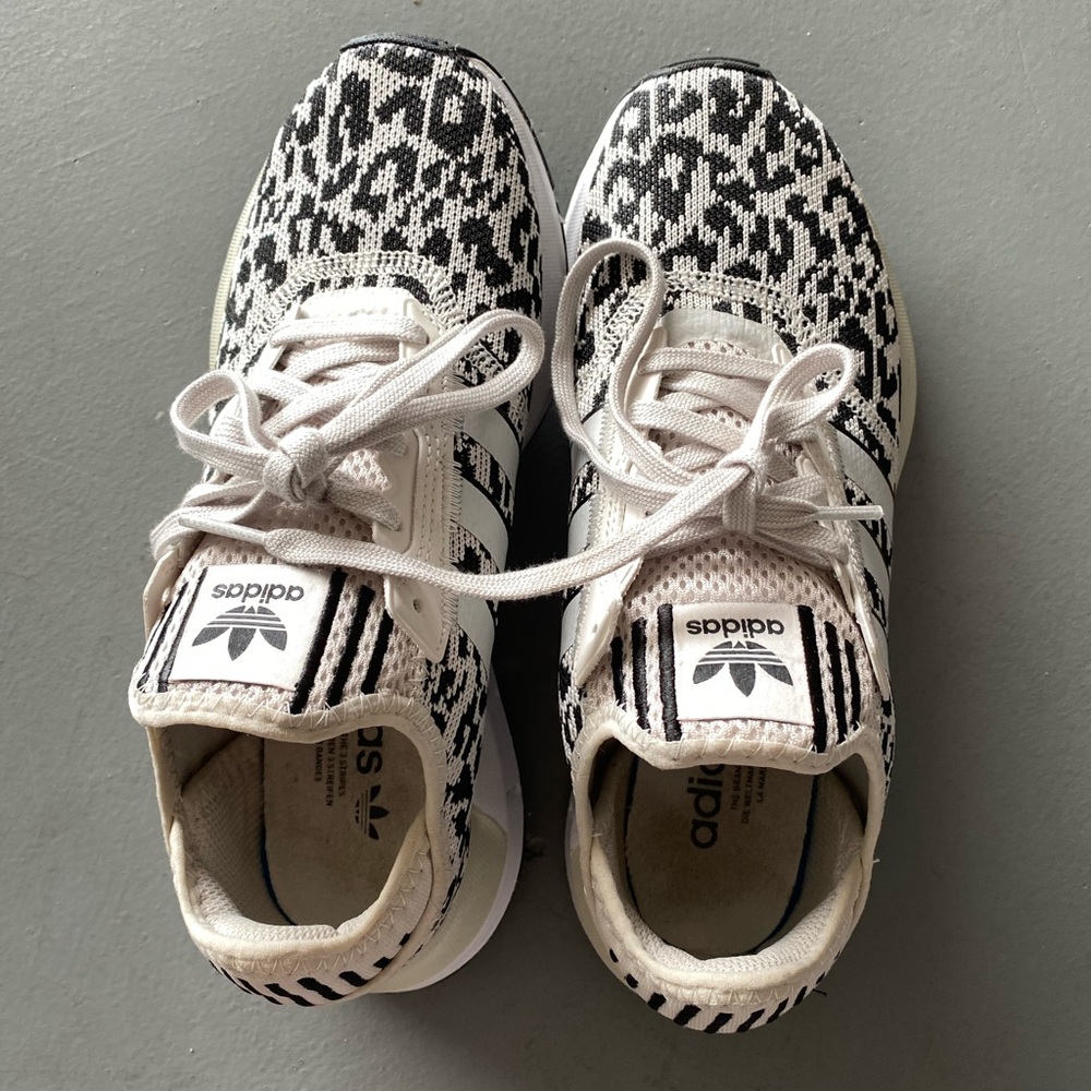 Adidas cream and black print athletic shoes.